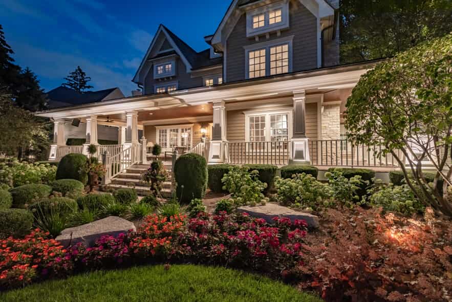Elegantly illuminated home at night, featuring professionally designed outdoor lighting that enhances the architecture and landscaping, ideal for promoting an outdoor lighting franchise.